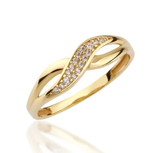 May include: A gold ring with a twisted band and a row of small clear stones.