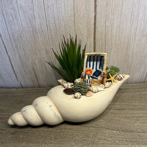 Maritimes Sommergesteck in Keramik-Schnecke mit Strandkorb & Muscheln – handgemachte Küstendeko