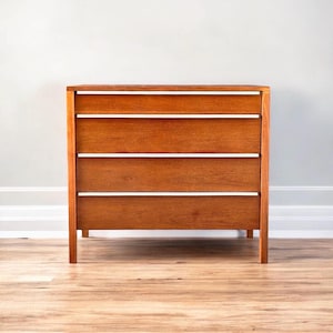 May include: A four-drawer dresser made of solid wood with a light brown finish. The dresser has simple, straight lines and a modern design.