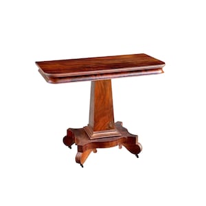 May include: A rectangular, antique wooden table with a dark brown finish. The table has a pedestal base and a decorative, curved edge. The table is approximately 30 inches long and 15 inches wide.