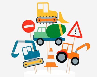 May include: A set of construction-themed party decorations. The set includes a yellow bulldozer, a green cement mixer, a blue excavator, a red tractor, a stop sign, a construction cone, and a warning sign with an exclamation point.