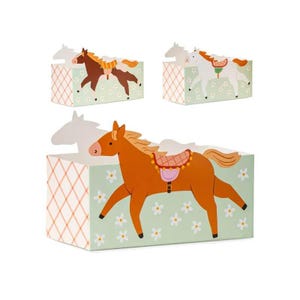 Puede incluir: Tres cajas decorativas con ilustraciones de caballos. Las cajas tienen un fondo verde claro con patrones de flores blancas y un patrón de cuadrícula en los lados. Los caballos son marrones y blancos con sillas de montar.
