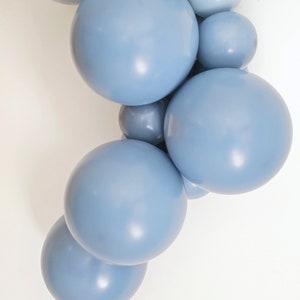 May include: A cluster of light blue balloons, arranged in a cascading pattern. The balloons are all the same color and size, and they are arranged in a way that creates a sense of movement and flow.