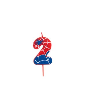 May include: A number 2 birthday candle in red, white, and blue, with a spiderweb design. The candle has a blue spider emblem and a red wick. Ideal for a birthday celebration.