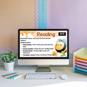 Può includere: Uno schermo di computer che mostra un piano di lezione di lettura con un'illustrazione di un'ape di cartone animato. Il piano di lezione include una lettura ad alta voce, una lettura silenziosa, una lettura in coppia, giochi di lettura e parole di vocabolario. Il testo sullo schermo dice "Lettura" e "Leggi ad alta voce oggi, leggeremo "Il gatto con il cappello" insieme."