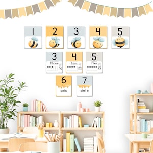 May include: A set of colourful bee-themed number cards for teaching children to count. The cards feature numbers 1 through 7, with a cute bee illustration and the number word written below. The cards are perfect for a classroom or homeschool setting.