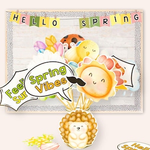 May include: A set of spring-themed photo booth props featuring a yellow sun with a smiling face, a speech bubble that says "Feel the Spring Vibes", a ladybug, a yellow chick, and a hedgehog. The props are arranged in a vase with a banner that says "Hello Spring" above them.