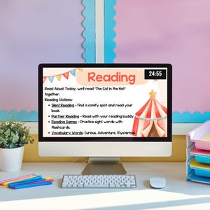 May include: A computer screen displaying a colourful reading lesson plan with a circus tent graphic. The lesson plan includes a read aloud activity, reading stations, and vocabulary words. The time is 24:55.
