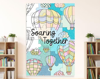 Puede incluir: Un colorido póster de arte mural con globos aerostáticos y formas de rompecabezas. El texto "Soaring Together" se muestra en una fuente caprichosa. La obra de arte tiene una paleta de colores pastel con tonos de rosa, amarillo y azul.