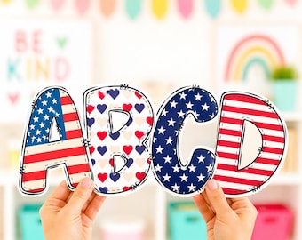 May include: The letters A, B, C, and D are held up in front of a blurred background. The letters are decorated with patriotic patterns: the American flag, hearts, and stars. The letters are outlined in black with a stitched border.