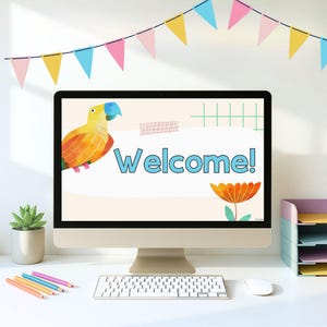 May include: A computer monitor displays a "Welcome!" message with a cartoon parrot and flower graphic. A keyboard, mouse, pencils, and a succulent plant are on the desk. A colorful banner hangs above the monitor.