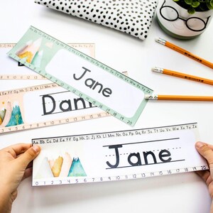 Può includere: Due etichette per nomi stampabili con un tema di montagna. Il nome "Jane" è scritto su entrambe le etichette. La prima etichetta ha uno spazio vuoto per scrivere il nome "Dan". La seconda etichetta ha una linea per scrivere il nome "Jane". Entrambe le etichette hanno una linea di numeri da 0 a 20.