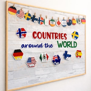 Könnte beinhalten: Eine holzgerahmte Pinnwand mit den Worten "COUNTRIES around the WORLD" in Rot, Blau und Grün. Die Tafel zeigt Länderflaggen in verschiedenen Formen, darunter Kreise und Sechsecke, die mit kleinen Holzklammern befestigt sind.