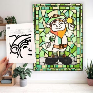May include: A stained glass style illustration of a leprechaun holding a four-leaf clover and a gold coin. The leprechaun is wearing a green hat, a green shirt, brown pants, and black shoes. The background is a green and yellow stained glass pattern.