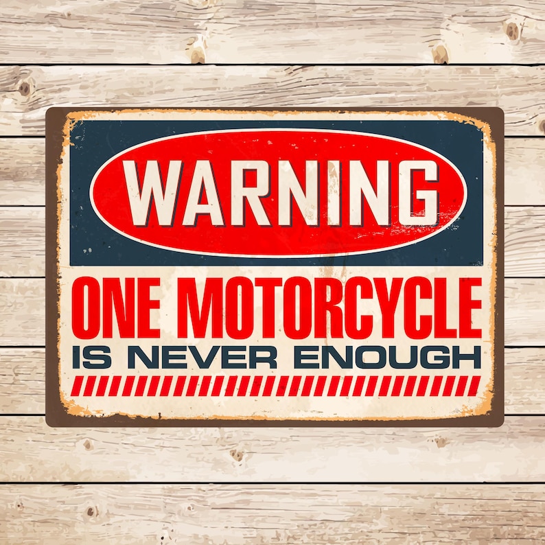 May include: A vintage-style metal sign with a red warning sign that says "WARNING" in white letters. The sign has a white background with blue borders and says "ONE MOTORCYCLE IS NEVER ENOUGH" in black letters with red stripes at the bottom.