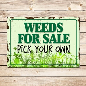 May include: A rusty metal sign with green text that reads "WEEDS FOR SALE PICK YOUR OWN". The sign has a green and white background with a silhouette of weeds at the bottom.