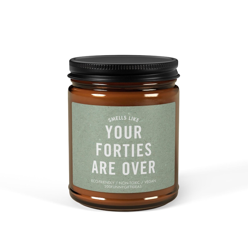 May include: A brown glass candle jar with a black lid. The label reads "Smells Like Your Forties Are Over" with the text "ECO-FRIENDLY / NON-TOXIC / VEGAN 200FUNNYGIFTIDEAS" below.