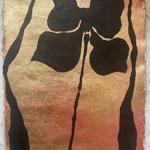 May include: A rectangular piece of paper with a deckled edge featuring a hand-painted design. The background is a gradient of metallic gold and soft pink. A bold, black abstract floral shape is centered, flanked by two vertical black lines.
