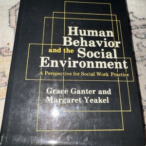May include: A black hardcover book titled Human Behavior and the Social Environment: A Perspective for Social Work Practice by Grace Ganter and Margaret Yeakel, featuring yellow geometric line graphics on the front cover.