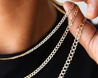 May include: Three gold chains of different thicknesses, layered and worn as a necklace.