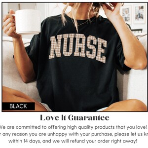 May include: Black t-shirt with the word "NURSE" in a plaid pattern across the chest. The person is holding a white mug. The shirt is part of a collection of apparel.