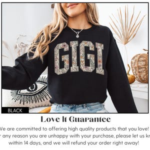 May include: Black sweatshirt featuring the word "GIGI" in a floral design. The long-sleeved sweatshirt has the word "BLACK" at the bottom left. The floral design is in shades of beige and brown.
