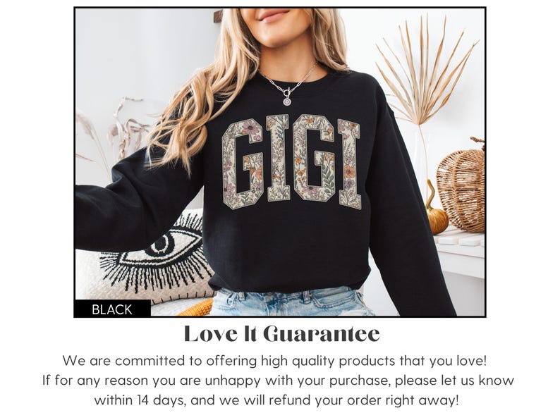 May include: Black sweatshirt featuring the word "GIGI" in a floral design. The long-sleeved sweatshirt has the word "BLACK" at the bottom left. The floral design is in shades of beige and brown.