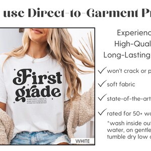 Puede incluir: Camiseta blanca con la frase "First Grade" en una fuente retro. La camiseta tambi&eacute;n tiene el texto "SOME DAYS I ROCK IT, SOME DAYS IT ROCKS ME, EITHER WAY WE ROCK IT." La imagen muestra una impresi&oacute;n directa sobre la prenda.
