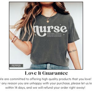 Pode incluir: T-shirt cinzenta escura com a palavra "nurse" em fonte retro branca. A camisa tamb&eacute;m apresenta o texto "SOME DAYS I ROCK IT, SOME DAYS IT ROCKS ME, EITHER WAY WE'RE ROCKIN". A camisa &eacute; de estilo casual.