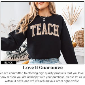 May include: Black sweatshirt with the word "TEACH" in a plaid design across the chest. The sweatshirt is a crew neck style. The word "BLACK" is in a black rectangle at the bottom left.