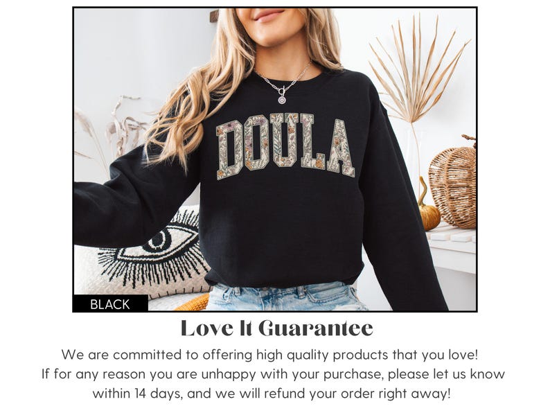 May include: Black sweatshirt with the word "DOULA" in floral print lettering. The sweatshirt is a crew neck style. The word "BLACK" is in a black rectangle at the bottom left of the image.