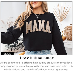 May include: Black sweatshirt with the word "MAMA" in a plaid pattern across the chest. The sweatshirt is part of a clothing collection. The word "BLACK" is in a black rectangle at the bottom left.
