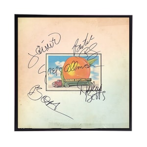 May include: A vintage vinyl record album cover featuring a peach on a truck. The album cover is signed by the band members: "Jaimoe", "Berry", "Gregg Allman", "Butch Trucks", and "Dickey Betts".