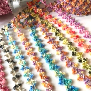 May include: A variety of colorful fuzzy trim with a delicate crocheted design. The trim is available in a range of colors, including pink, blue, yellow, and green.