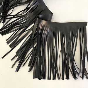 May include: Black leather fringe trim with a smooth, shiny finish. The fringe is approximately 1 inch long.