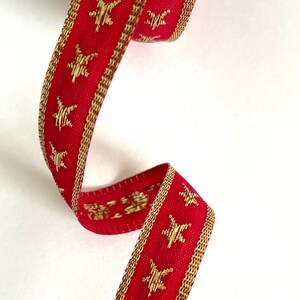 Puede incluir: Cinta roja con estrellas doradas y ribete dorado.