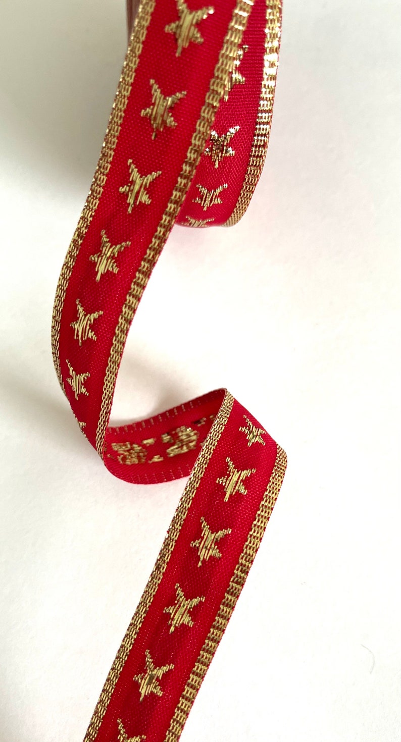 Puede incluir: Cinta roja con estrellas doradas y ribete dorado.