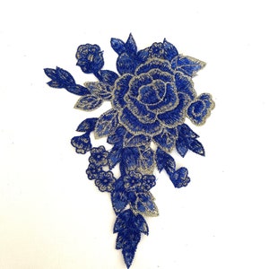 May include: Blue and silver embroidered floral applique with a large rose and smaller flowers and leaves.