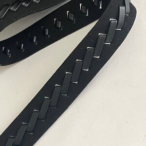 May include: Black braided leather trim with a diamond pattern cut-out. The trim is approximately 1 inch wide.