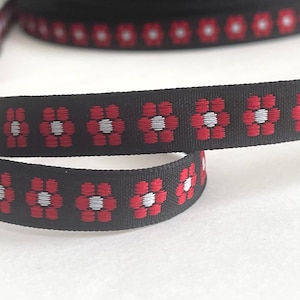 May include: Black ribbon with a repeating pattern of red and white flowers.