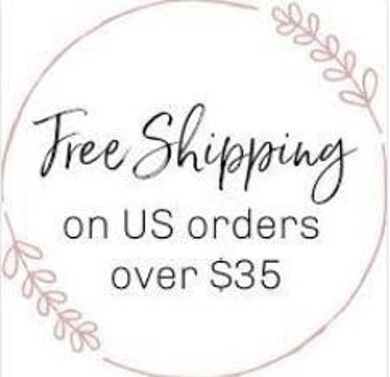 May include: Circular graphic with the words "Free Shipping" in elegant script, followed by "on US orders over $35". The design includes delicate floral accents around the circle's edge.