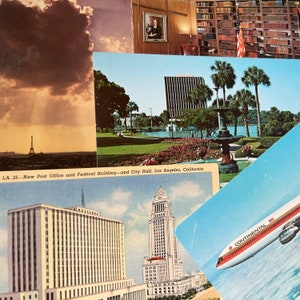 May include: A vintage postcard featuring a view of the Los Angeles City Hall, the New Post Office and Federal Building, and a fountain in a park. The postcard is titled "LA. 26 - New Post Office and Federal Building - and City Hall, Los Angeles, California."