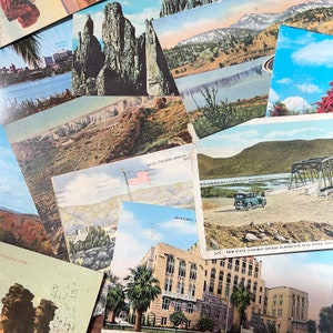 May include: A collection of vintage postcards featuring various scenic locations, including a bridge over a river, a mountain range, and a building with a sign that reads "Maricopa County".