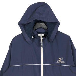 Puede incluir: Chaqueta con capucha azul marino con cremallera y ribetes blancos. El logotipo "courr&egrave;ges" es de color beige claro en el pecho. La capucha est&aacute; forrada con un material azul m&aacute;s oscuro. Una prenda de vestir exterior cl&aacute;sica.