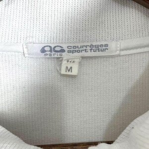 Puede incluir: Primer plano de la etiqueta de una camisa blanca con cuello. La etiqueta presenta la marca "courr&egrave;ges sport futur" y la talla "M". La etiqueta tambi&eacute;n incluye el texto "Paris" y caracteres japoneses.