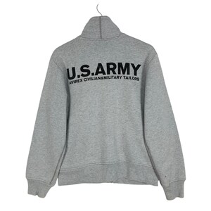May include: A gray zip-up sweatshirt with the text "U.S.ARMY" in large black letters across the back. Below the text is the text "AVIREX CIVILIAN&MILITARY TAILORS" in smaller black letters. The sweatshirt has a high collar.