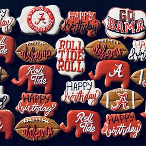 Könnte beinhalten: Eine Sammlung von 18 dekorierten Zuckerkeksen mit den Farben und Logos der University of Alabama. Die Kekse zeigen Bilder von Elefanten, Fußbällen und die Worte "Roll Tide", "Happy Birthday" und "Go Bama".