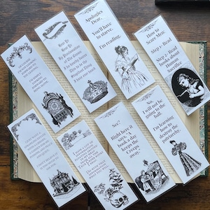 May include: A collection of white bookmarks with black illustrations and text. The bookmarks feature quotes, images of crowns, clocks, and figures. The text includes phrases like "I'm reading" and "How to Scare Men."