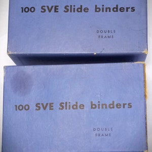 May include: Two blue boxes with the text "100 SVE Slide binders Double Frame" printed on them.