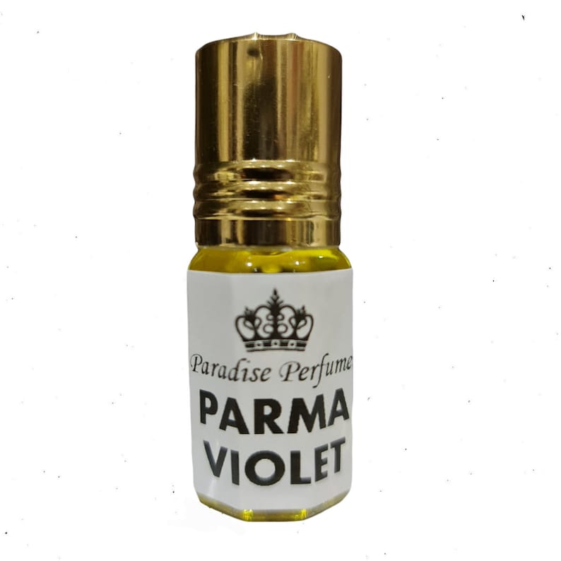 May include: A small, clear glass bottle with a gold cap and a white label. The label has a crown and the text "Paradise Perfume PARMA VIOLET".
